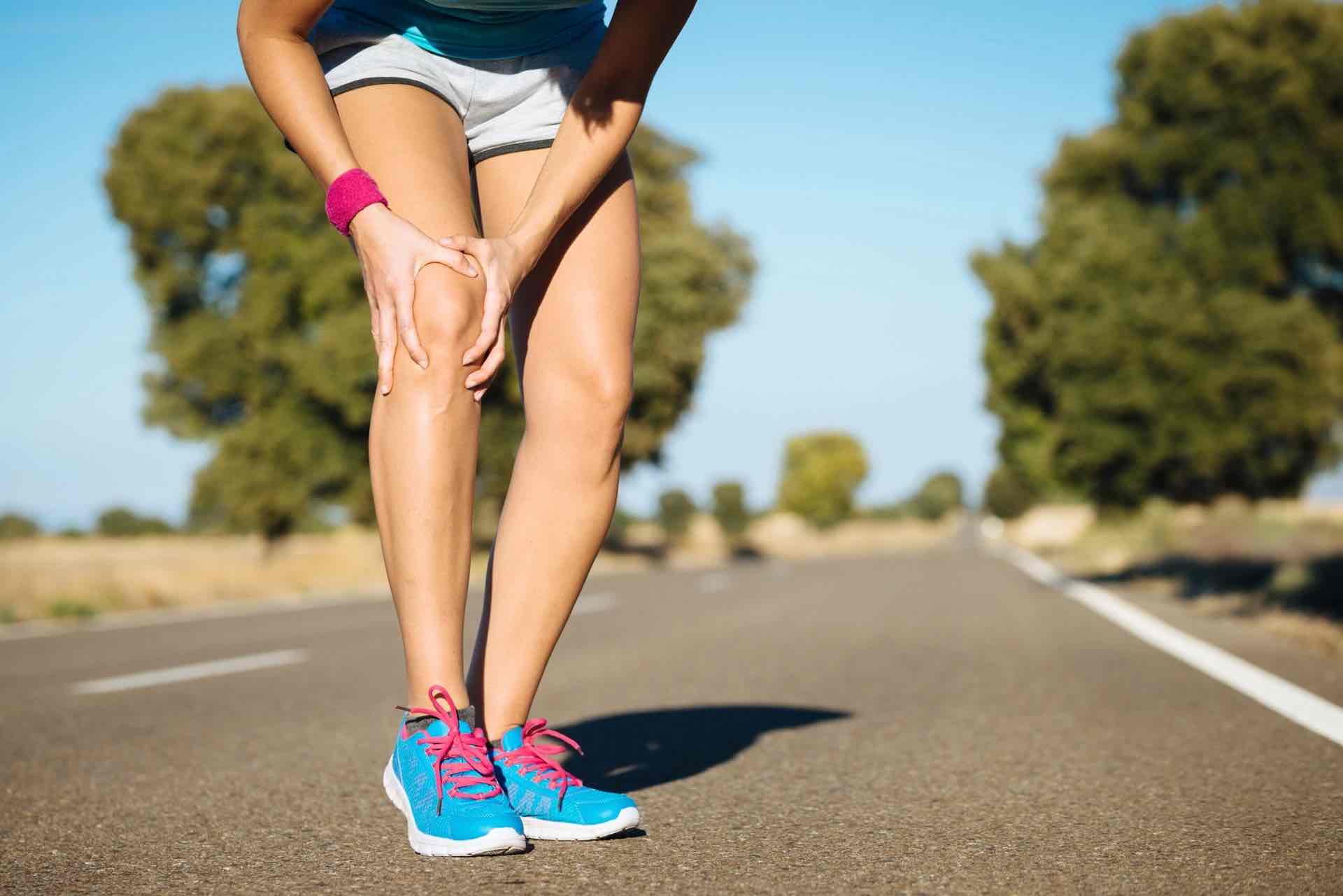 Person with knee arthritis holding the knee while walking