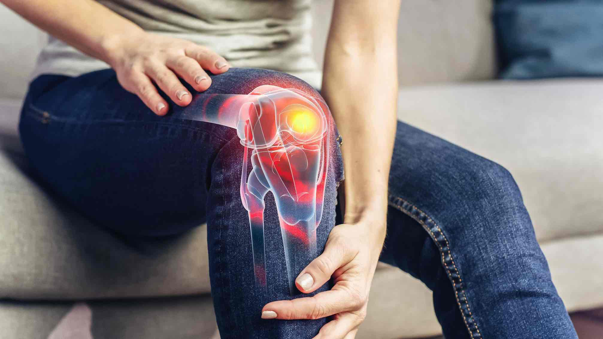 Woman holding her knee in pain, close-up of the knee